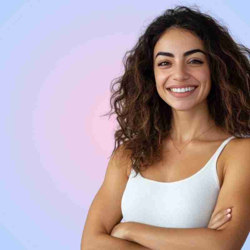 Smiling woman with curly hair showcasing a bright, confident smile, representing cosmetic dentistry and smile enhancement at Jax Dental Arts.